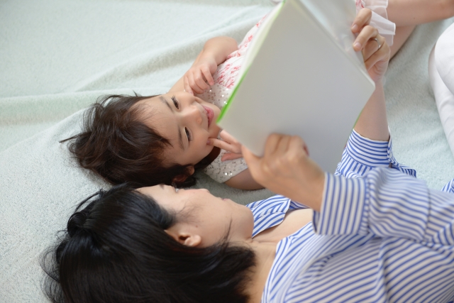 子供に本の読み聞かせをしている母親の写真