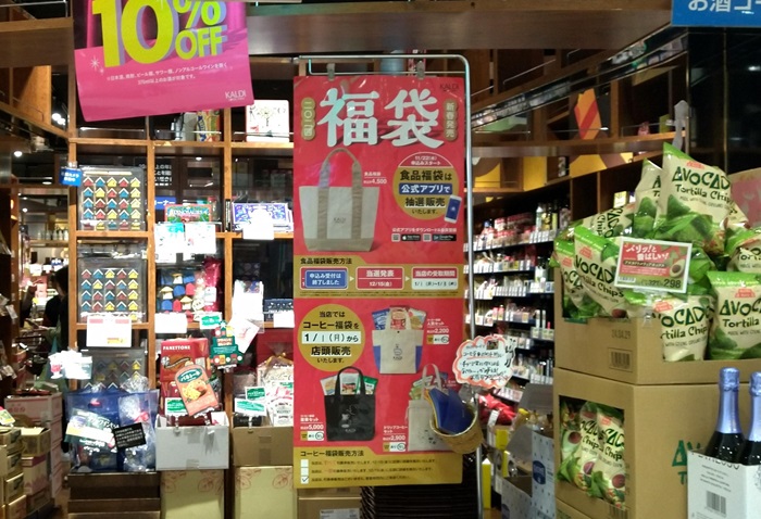 カルディの店頭に福袋販売の詳細のポスターが張り出されている風景